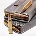 Two loaded rifle magazines with 223 caliber bullets with two additional bullets outside of them Royalty Free Stock Photo