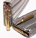Two loaded rifle magazines with 223 caliber bullets with two additional bullets outside of them Royalty Free Stock Photo