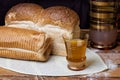 Two loaves of fresh bread with carafe and glass with kombucha