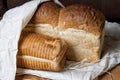 Two loaves of fresh bread in sackcloth on wooden table