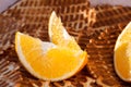 Two lobules of orange on a background of crispy waffles close-up