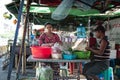 Two local burmese people prepares food at a stall in central Yangon