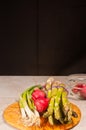 Two local, ripe, radish, bundle of asparagus, four green onions and pairing knife, on a rare wood plate