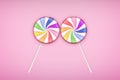 Two Lolipops candy on pastel pink background.