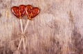 Two lollipop on the old wooden background. Sweet heart on stick.