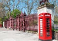 Two London bright red phone cabins infront big door