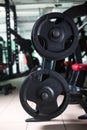 Two long barbells on a stand. Barbell holder on a blurred gym background. Heavy, huge black dumbbells. Sport equipment. Royalty Free Stock Photo