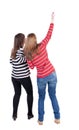 Two long haired friendly women pointing . Royalty Free Stock Photo
