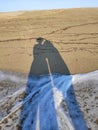 Two long shadows of a loving couple on lovely lonely beach Royalty Free Stock Photo