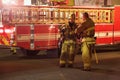 Two Los Angeles Fire Department firemen next to fire trucks