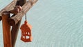 two lovebirds sit above a pool. terracotta lantern is on the wooden doves beam. pigeons snuggle over the glistening sea water Royalty Free Stock Photo