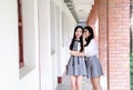 Two lovely Asian Chinese pretty girls wear student suit in school best friends smile laugh talking and gossip Royalty Free Stock Photo