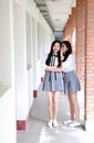 Two lovely Asian Chinese pretty girls wear student suit in school best friends smile laugh talking and gossip Royalty Free Stock Photo