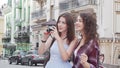 Two lovely female friends taking photos of the city while travelling together Royalty Free Stock Photo