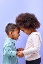 two lovely kid friends hugging holding hands together isolated over purple Royalty Free Stock Photo