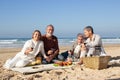 Two lovely senior couple enjoying picnic on sandy beach Royalty Free Stock Photo