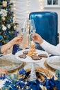 Two lovers celebrate Christmas or New Year with champagne, against the background of a festive table, a Christmas tree.