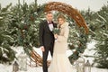 Two lovers, a man and a woman, a wedding in winter. bride and groom love. against the backdrop of decor and trees, snow. holding a Royalty Free Stock Photo