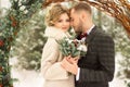 Two lovers, a man and a woman, a wedding in winter. bride and groom love. against the backdrop of decor and trees, snow. holding a Royalty Free Stock Photo