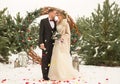 Two lovers, a man and a woman, a wedding in winter. bride and groom love. against the backdrop of decor and trees, snow. holding a Royalty Free Stock Photo