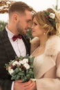 Two lovers, a man and a woman, a wedding in winter. bride and groom love. against the backdrop of decor and trees, snow. holding a Royalty Free Stock Photo