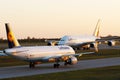 Two Lufthansa airplanes taxiing face to face. Airbus A380 and a small aircraft
