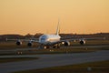 Two Lufthansa airplanes taxiing at sunrise, Airbus A380 and a small aircraft