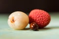 Two lychee fruits and seed wooden background Royalty Free Stock Photo