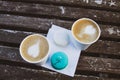Two macaroons of mint and white, two coffee in paper cups, on a wooden vintage table. Royalty Free Stock Photo