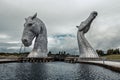 Two majestic horse statues standing tall against a cloudy sky in Kelpher.