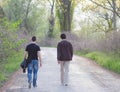 Two male adult friends walking in nature on sunny spring day