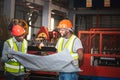 Two male African American maintenance engineers, are working and looking at blueprint