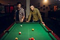 Two male billiard players with cue, poolroom Royalty Free Stock Photo