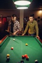 Two male billiard players with cue, poolroom Royalty Free Stock Photo