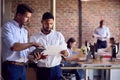 Two Male Business Colleagues With Digital Tablet And Documents Meeting In Busy Office Royalty Free Stock Photo