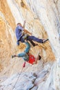 Two male climbers hanging on a rope.