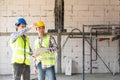 Two male construction engineers from Asia, working together, Consulting and using a notebook computer