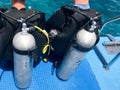 Two male divers in black diving waterproof suits with shiny metal aluminum canisters are preparing to dive from the boat to the bl Royalty Free Stock Photo