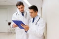Two male doctors with clipboard at hospital