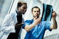 Two mixed race male doctors examining x-ray on modern office of hospital Royalty Free Stock Photo