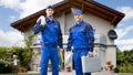 Two Male Electrician In Front Of House