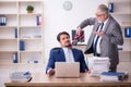 Two male employees working in the office in bullying concept Royalty Free Stock Photo