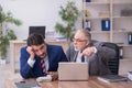 Two male employees working in the office in bullying concept Royalty Free Stock Photo