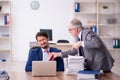 Two male employees working in the office in bullying concept Royalty Free Stock Photo