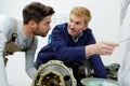 Two male engineers working with new project on drawing board