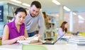 Two male and female students studying together in library Royalty Free Stock Photo