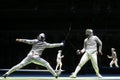 Two male fencing athletes fight