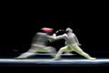 Two male fencing athletes fight