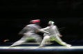 Two male fencing athletes fight