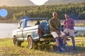 Two Male Friends With Backpacks In Pick Up Truck On Road Trip By Lake Drinking Beer Royalty Free Stock Photo